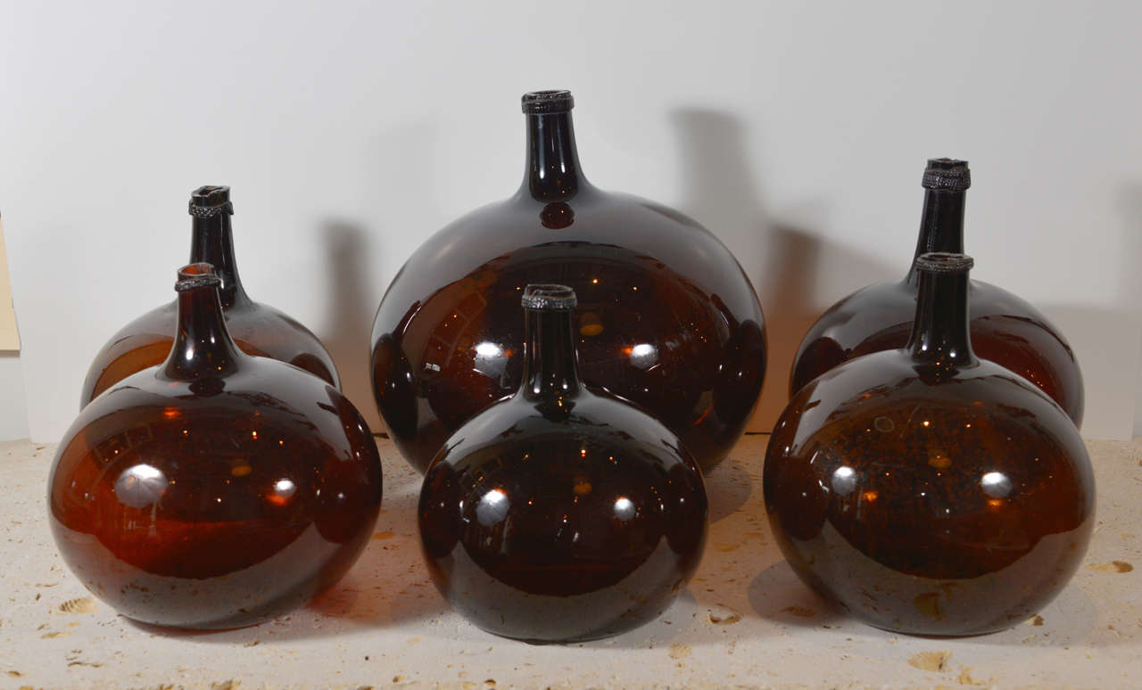 Handblown glass bottles with a wonderful shape and rich brown color. These are priced individually. The smallest is $ 300. The  middle one is $400, and the large is $500.
They verity is height from 10 inches; to 16 inches.