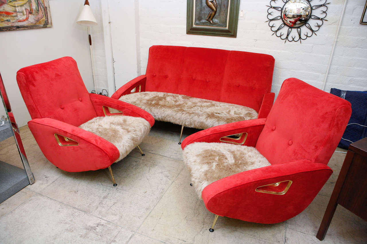 An exuberant Midcentury sofa set by Maurice Mourra, reminiscent of the jet age Jetsons style. Newly recovered in red velvet and a light brown flokati fur. This set is accented with brass legs and brass borders on the triangular armholes. Measures: