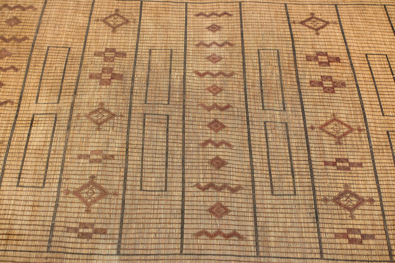Moroccan Tuareg leather mats are made of dwarf palm tree fibers and hand-woven with leather stripes, this are great to use indoor or outdoor, beautiful brown earth-tone colors. This vintage mid century rugs are made in the desert of Morocco near