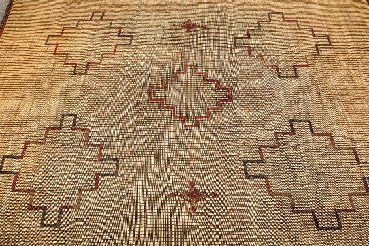 Moroccan Tuareg leather mats are made of dwarf palm tree fibers and handwoven with leather stripes, this are great to use indoor or outdoor, beautiful brown earth-tone colors. This vintage Mid-Century rugs are made in the desert of Morocco near