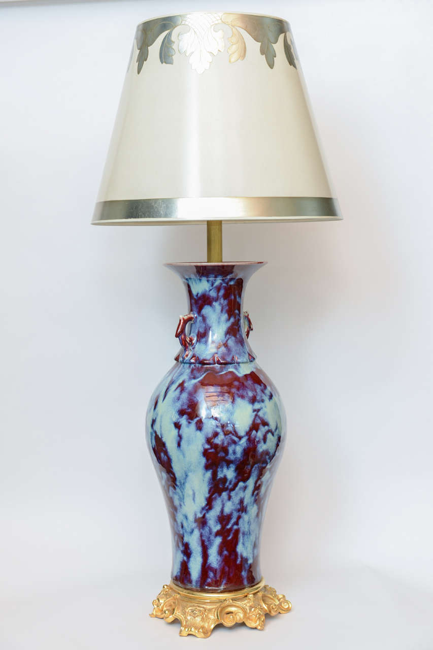 A massive pair of Chinese porcelain aqua and burgundy flambe bronze-mounted vase lamps.