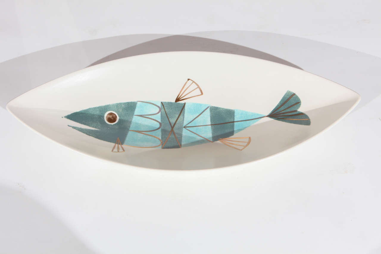 An impressive Metlox fish centerpiece bowl. Bowl is boat shaped with a midcentury style fish in blue and gold. Has a partial Metlox paper label on the base.