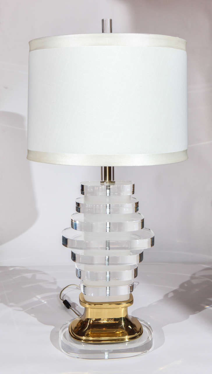Eine erstaunliche Vintage-Lampe aus Lucite und Messing. Besteht aus dick geschliffenen, abwechselnd klaren und mattierten Lucite-Ovalen in abgestuften Größen, die zu einer eleganten Basis gestapelt sind. Beschläge aus Messing. Der Lampenschirm ist