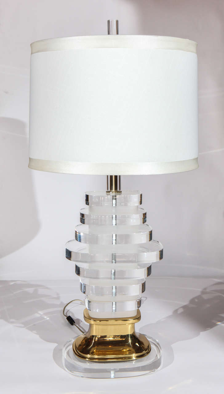 Un'incredibile lampada vintage in lucite e ottone. Si tratta di ovali di lucite trasparente e smerigliata, di dimensioni variabili, impilati a formare un'elegante base. Ferramenta in ottone. L'ombra è vecchia e dovrebbe essere sostituita.

La base