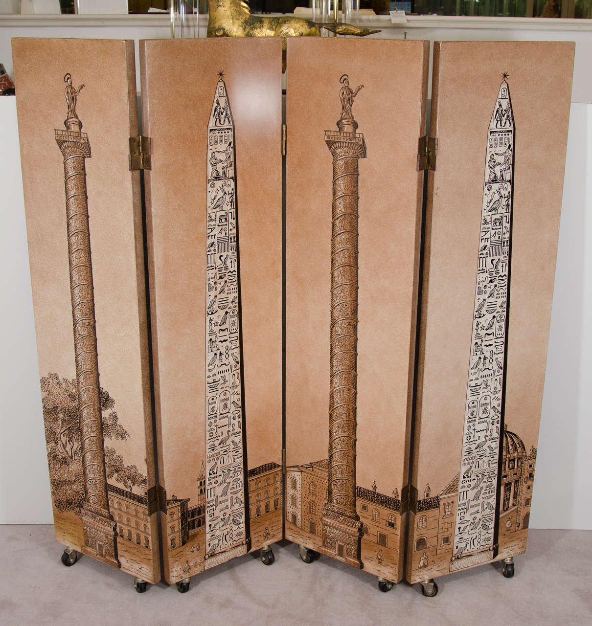 A 20th century four-panel screen or room divider on casters by Fornasetti with scenes of obelisks with hieroglyphics and saints on top of columns. Retains its original label.

Good vintage condition with age appropriate wear. Some chips to lacquer.