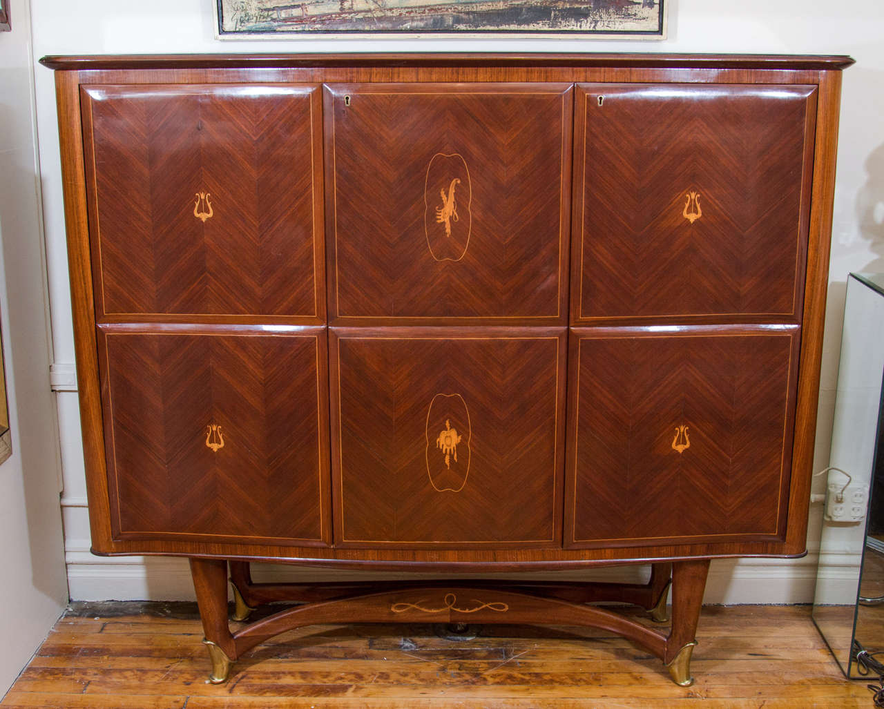 A vintage rosewood bar cabinet circa 1940s attributed to Milanese architect and designer Paolo Buffa with mirror and glass interior and polished brass feet.

Good condition with age appropriate wear. A few scars to the wood. A chip and loss of