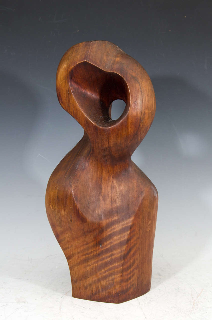 A vintage wooden sculpture of a female figure by American artist Jean Sampson titled 