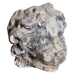 Fragment Of A Sculpted Stone Head Of A Putto