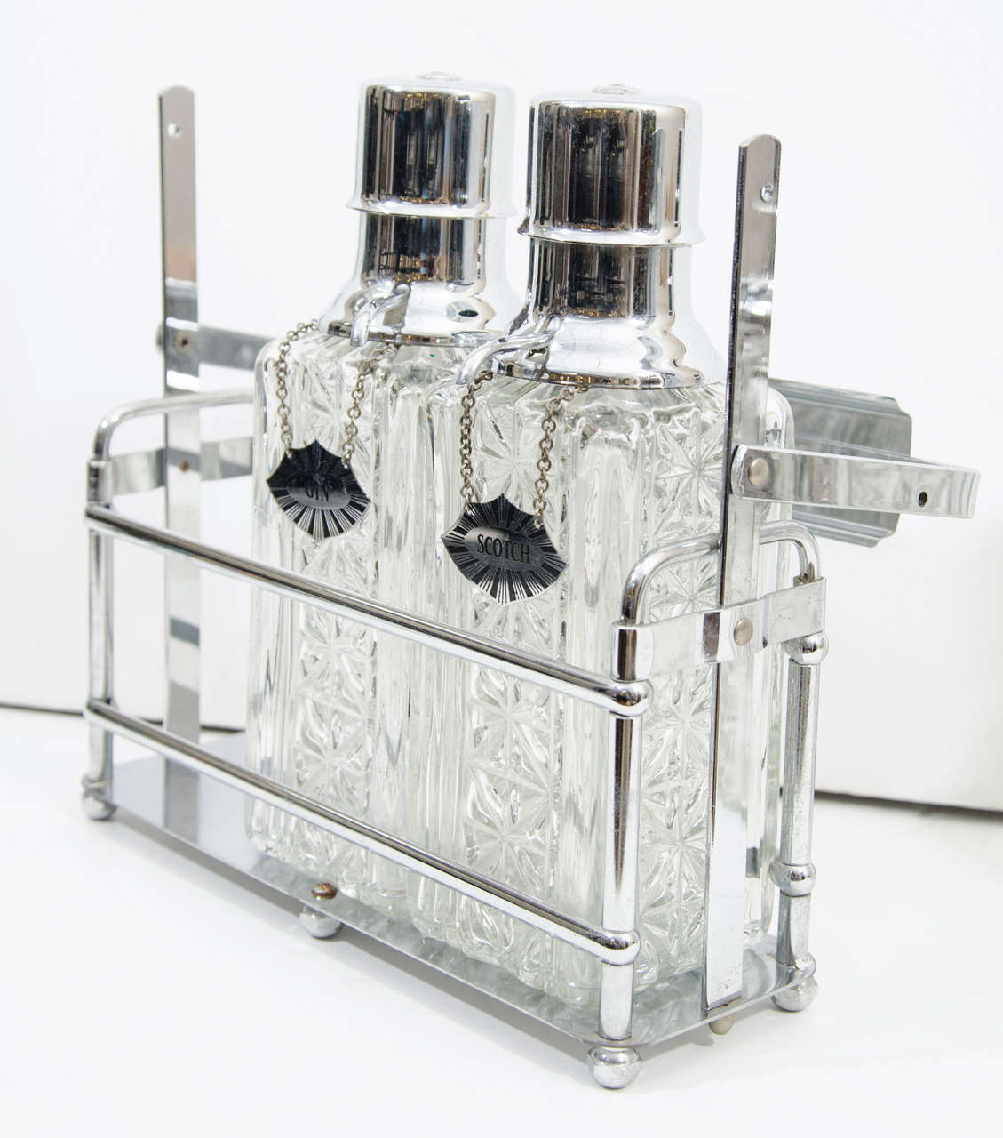 A vintage bar set consisting of three etched glass decanters with chrome lids and labels in a chrome stand

Reduced from: $450