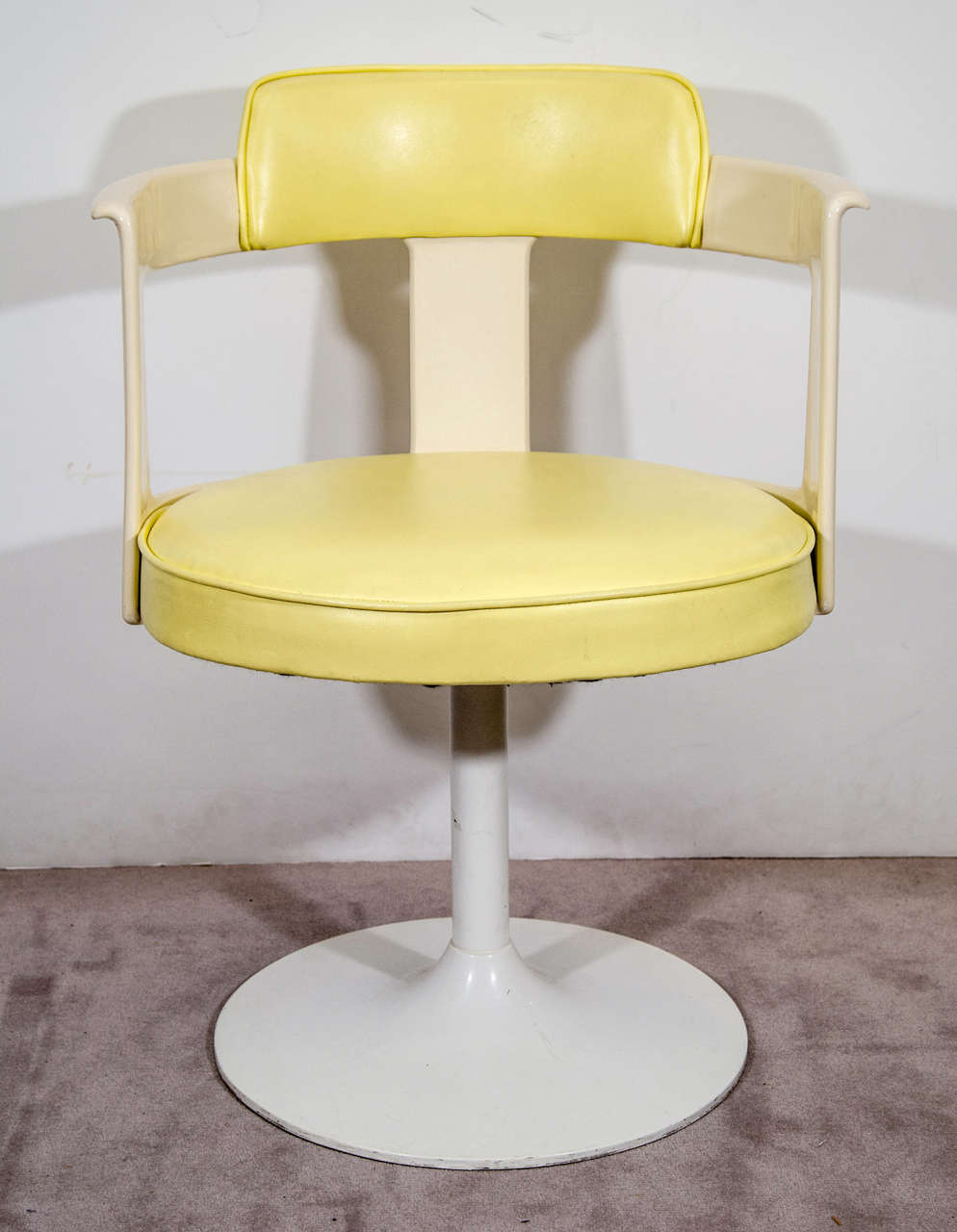 A pair of tulip chairs by Daystrom Furniture, produced circa 1960s-1970s, following the style of Eero Saarinen, with yellow vinyl seats against white arms and pedestal bases. Good vintage condition, with age appropriate wear.