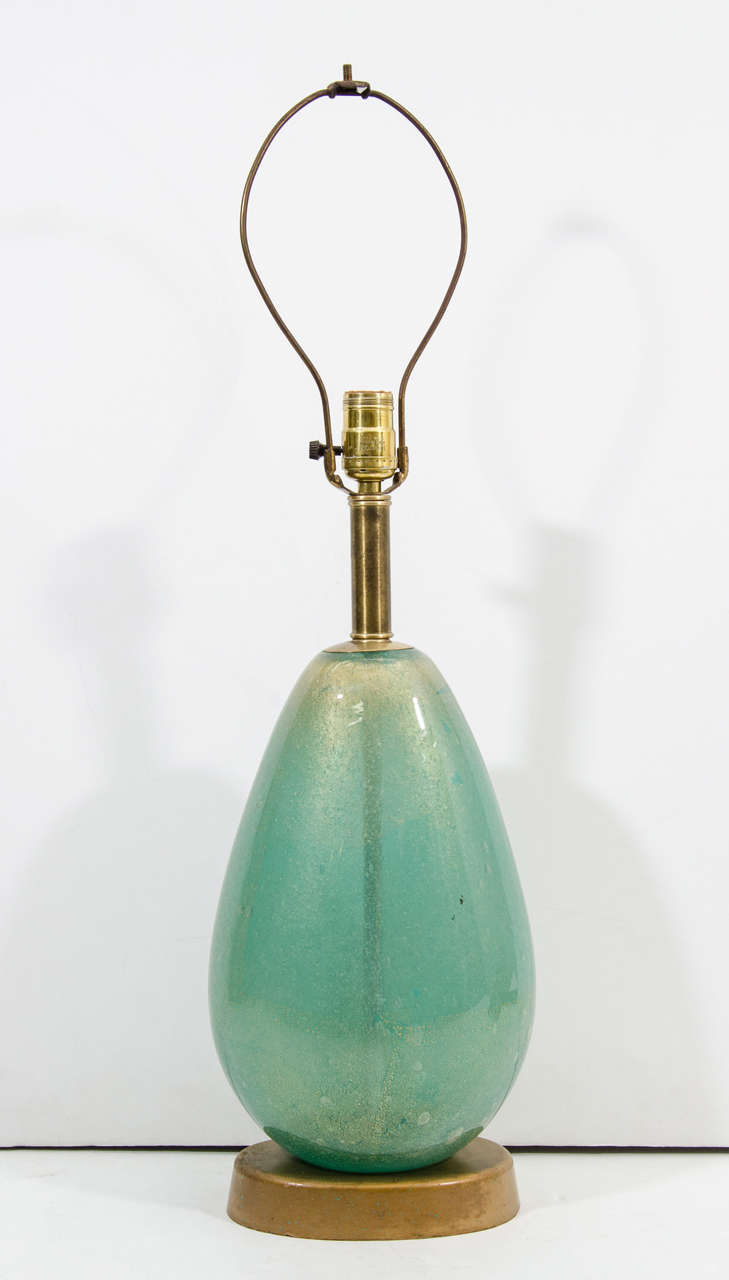 A single vintage table lamp in thick sea-foam green Murano glass infused with gold fleck accents on gilt wood bases. They are by Flavio Poli for Seguso. Good vintage condition with age appropriate wear; some scratches on bases