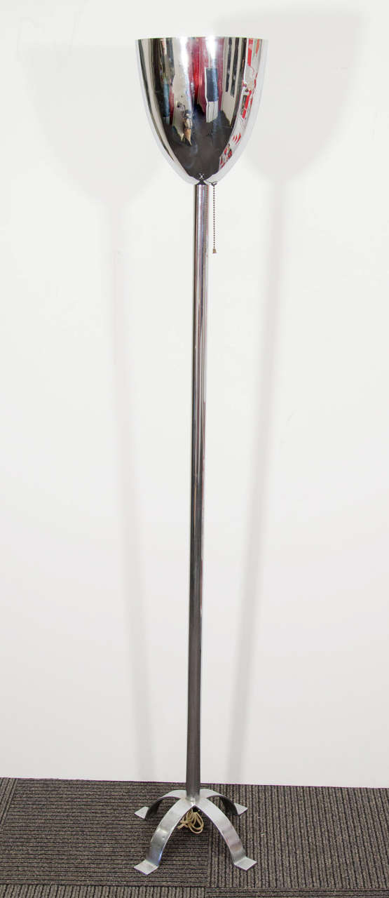 A vintage Art Deco torchiere floor lamp by noted designer Donald Deskey. The piece is in Polished nickel with a four-footed base. It is pictured in a Deskey room setting on page 43 of Donald Deskey: Decorative Designs and Interiors by David A. Hanks