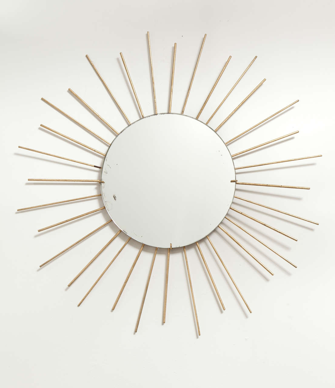 Grande specchio da parete a stella in ottone, Francia, circa 1960. Presenta uno specchio rotondo con cornice invisibile e aste in ottone di lunghezza alternata.  

Dimensioni:
28 pollici di diametro.
Diametro dello specchio 12 pollici.