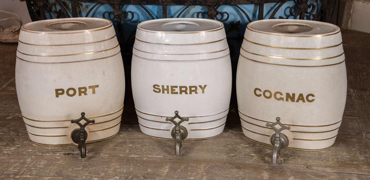 Set of 3 19th century ironstone spirit barrels, each oval shape with a cork bung, brass tap and gilt banded decorations with a label (port, sherry, and cognac).