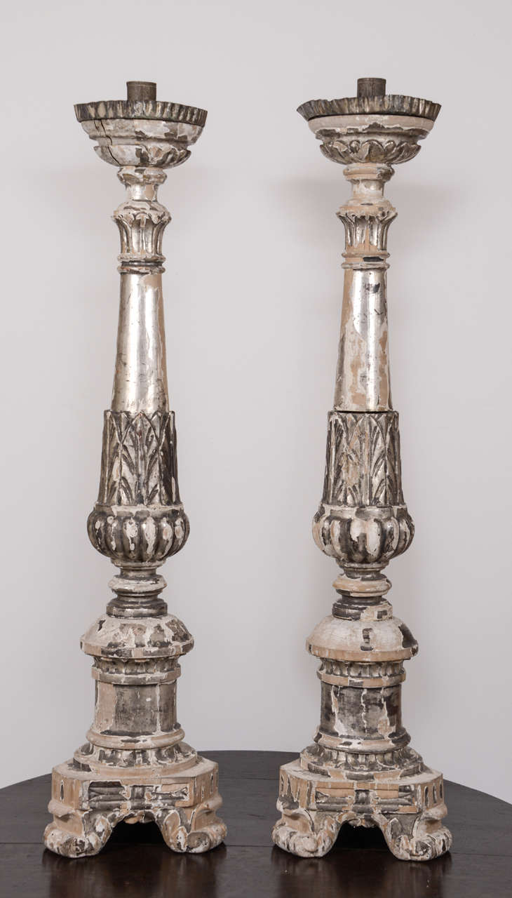 Pair of large ornately carved silver gilt wooden Italian candlesticks.