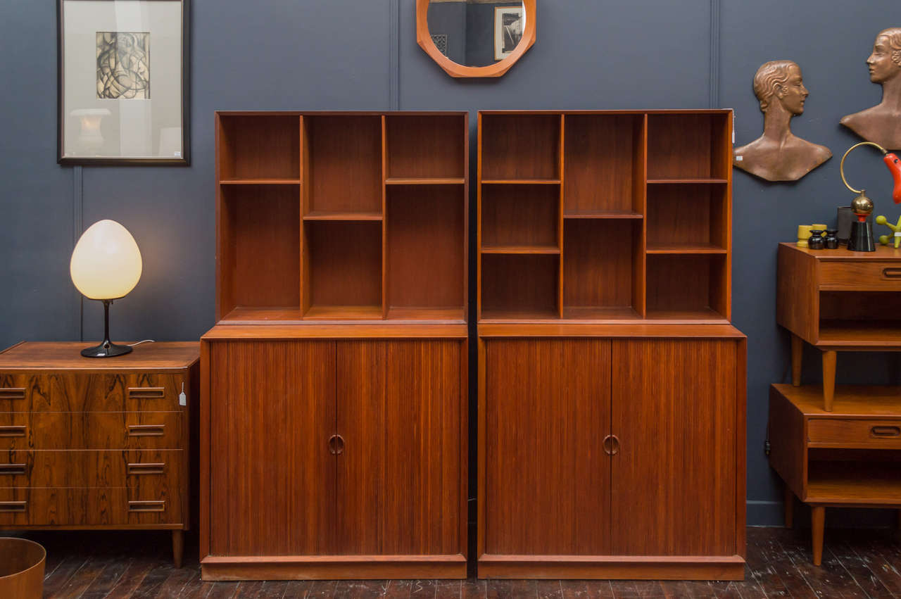 High quality dovetail construction teak tambour door two piece bookcase. Lower cabinet has three adjustable shelves, very good vintage condition, labeled. 
Two bookcases available.