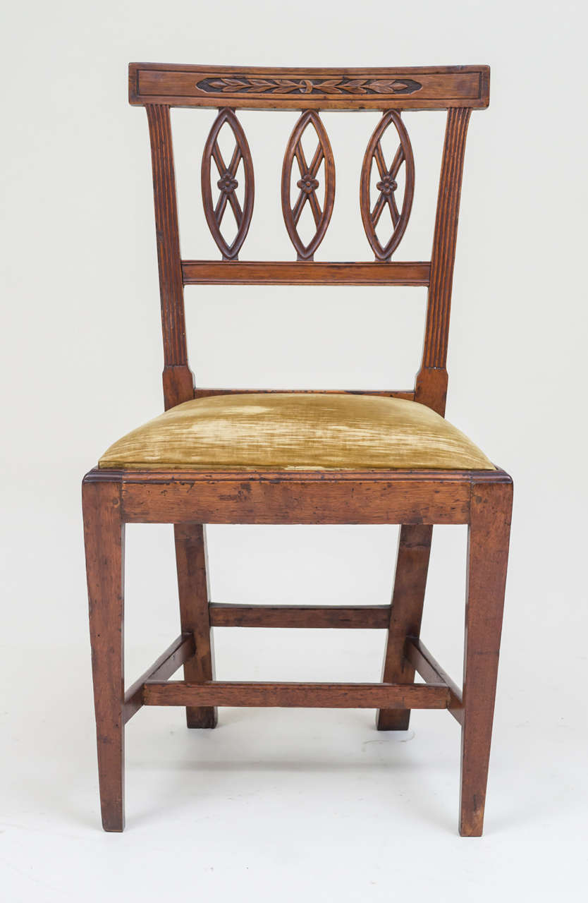 Set of six Italian neoclassic period side chairs. Walnut. All matching with elegant carved backs and ovoid floating elements. Good aged walnut patina. Drop seats retaining an old velvet cover.