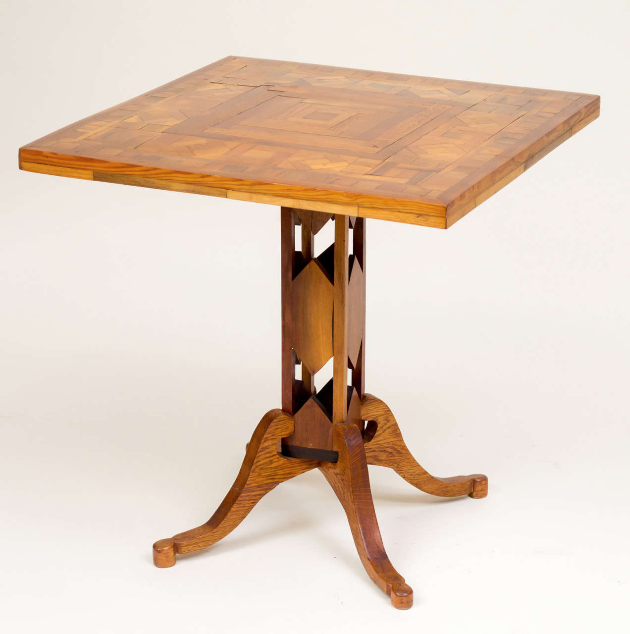 Early 20th century American Folk Art pedestal table. Interesting open work column supported by four curvilinear shaped oak legs. Intricate marquetry top, circa 1910-1920.