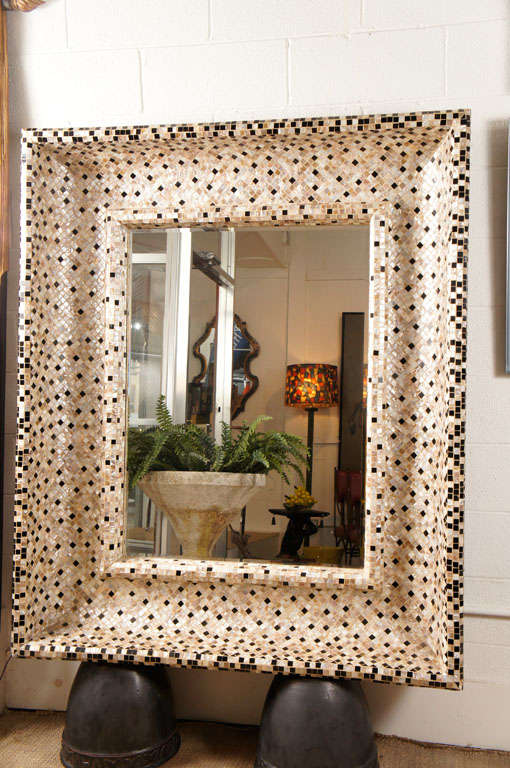 Here is a great mirror with mother of pearl and black tiles.
The frame has a deep inset and the mirror is beveled.