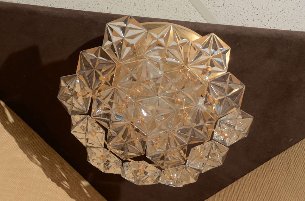 Schöner Kronleuchter in facettiertem Prismenkristall von Kinkeldey. Der Rahmen ist aus schönem poliertem Messing und hat Sternprismen, die bei Beleuchtung schimmern.