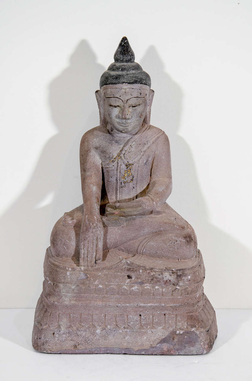 A beautiful, two hundred year old Burmese sandstone Buddha sitting in the Bhumisparsa mudra position (calling earth to witness).  This spiritual and serene  piece, from a Buddhist temple,  is expertly carved with an attractive color and patina. 