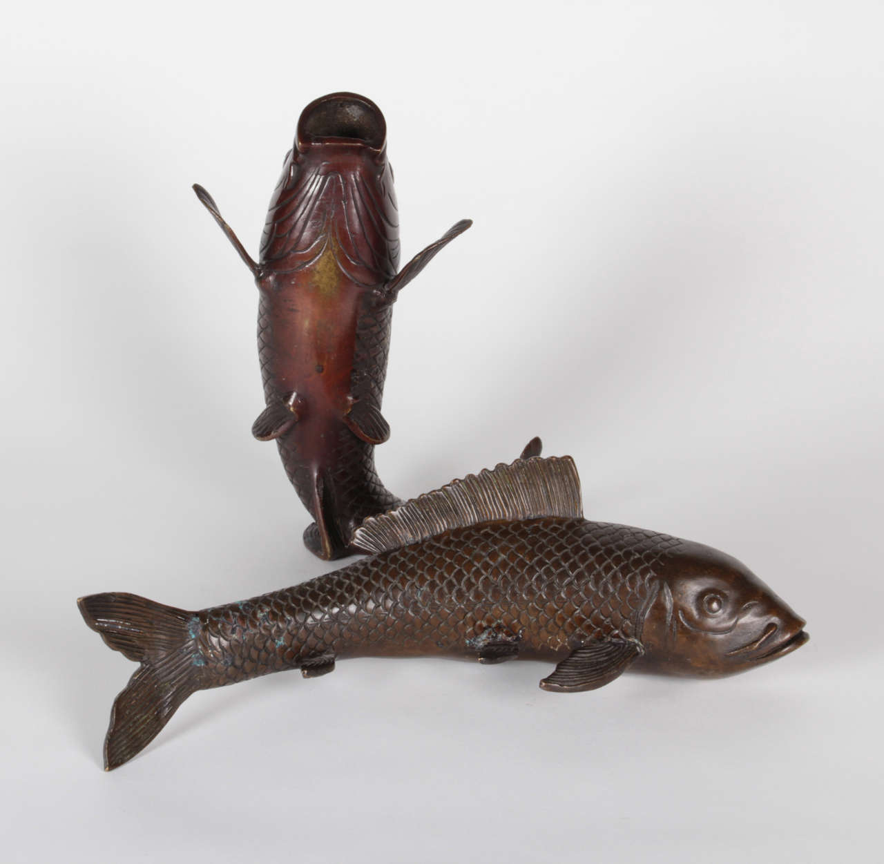 MEIJI PERIOD  (1868-1912)  Japan

Koi fish sculpture and vase c. 1900

Cast bronze realistically modeled as a swimming Koi sculpture and a jumping arched Koi vase with a rich brown patina. 

Swimming Koi: L: 11 1/4