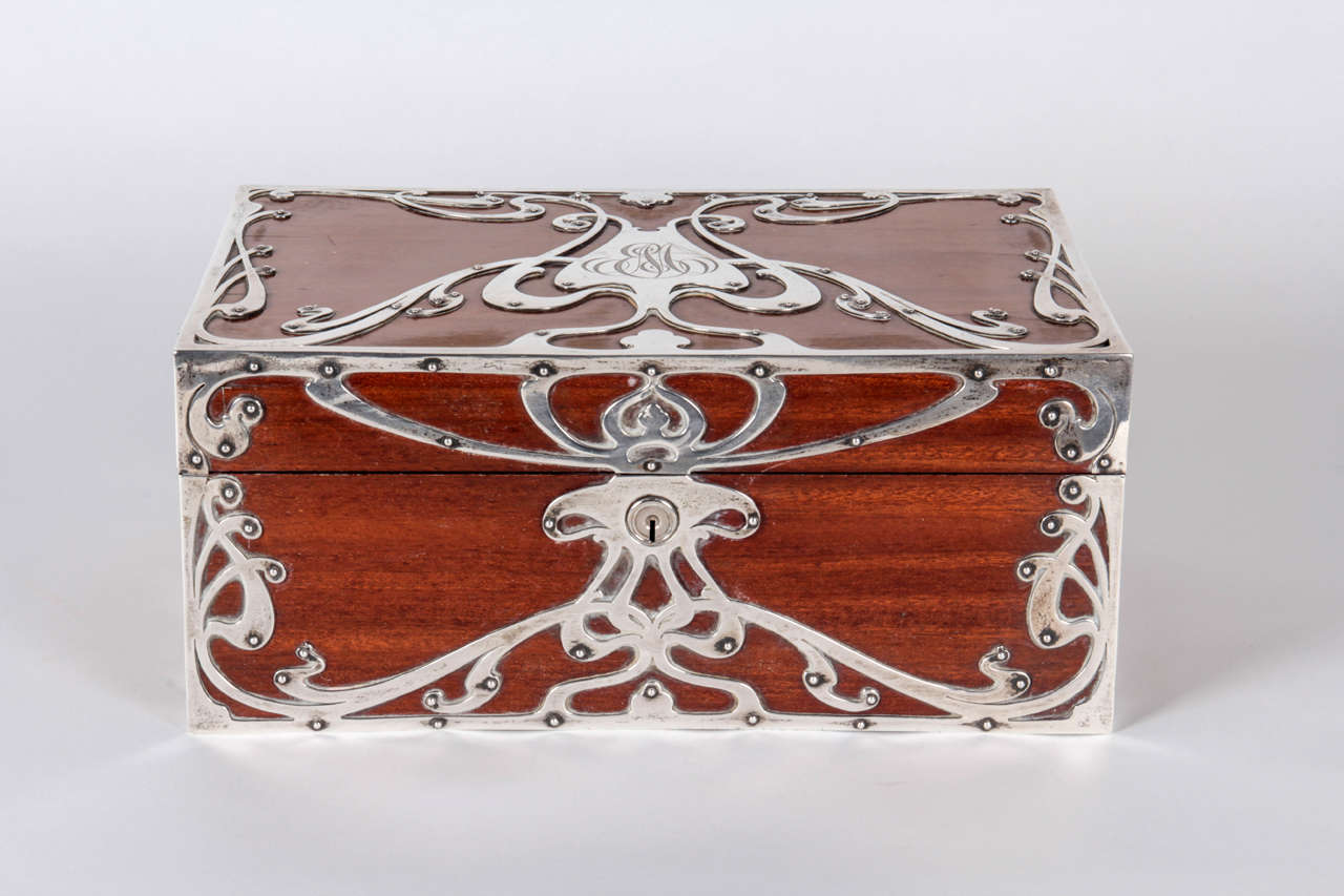 Black Starr & Frost New York, NY 

American Art Nouveau sterling and mahogany jewelry box, circa 1900

Mahogany jewelry box with thick sterling silver decorative graphic mountings in an elaborate Art Nouveau whiplash design, original