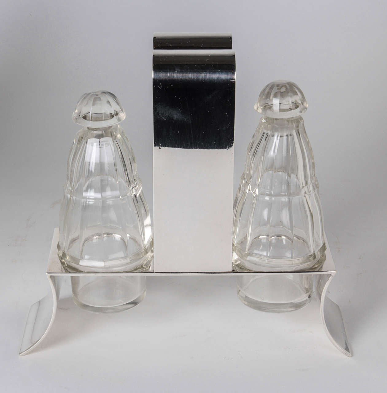 JOSEF HOFFMANN (1870-1956)  Austria

WIENER WERKSTÄTTE (1903-1932)  Vienna	

Cruet Set  c.1922

Silver plated stand with original cut crystal paneled bottles

Model illustrated: Wiener Werkstätte G.M.B.H.  catalog (December 1923), kat. nr. M