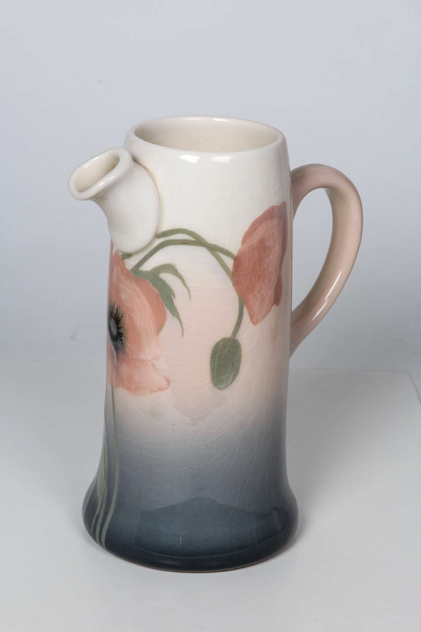 SARA SAX  (1870-1949)  
ROOKWOOD POTTERY   Cincinnati, OH

“Poppy” pitcher 1906

High fire ceramic with “Iris” glaze depicting five salmon pink poppies in various stages of blooming all on a rare handled pitcher form.

Marks: RP insignia, VI