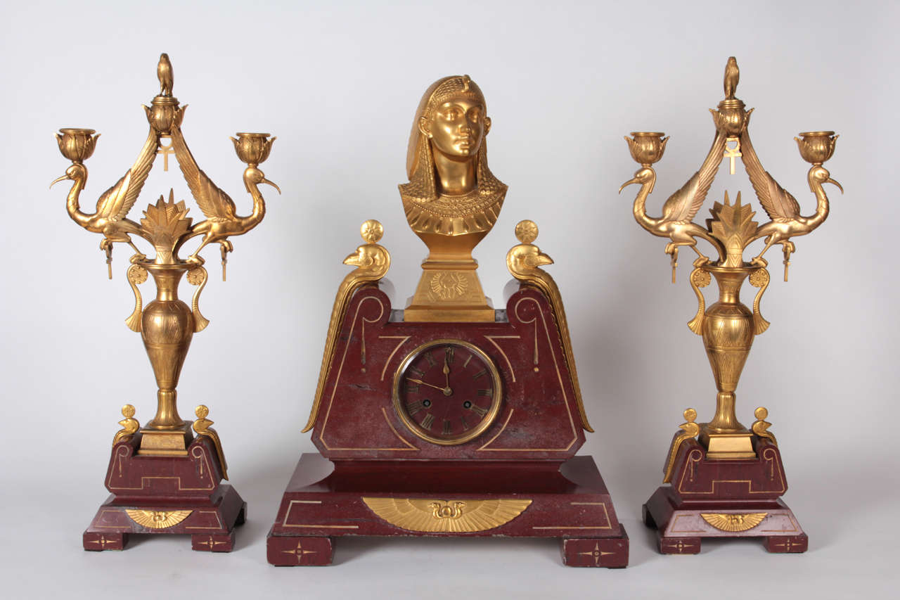 Paul-Auguste Gagné (Sculptor) France

Egyptian Revival garniture set, circa 1875

Gilt bronze and carved rouge marble mantle clock and candelabra in a high Egyptian Revival style   

Marks: P.A. Gagne (elaborate incised scroll signature on