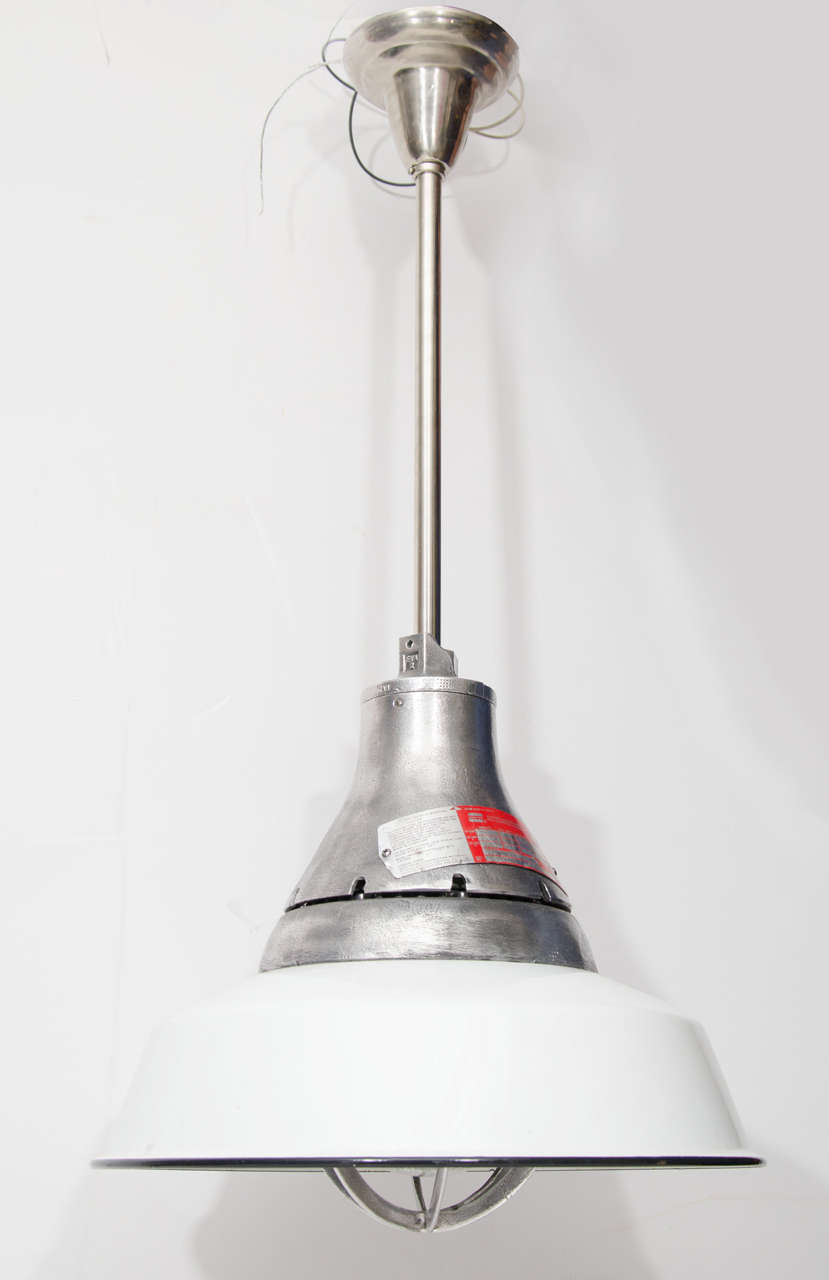 Industrial hanging pendant lights with white metal shades and signed metal tops.  
Priced per unit.