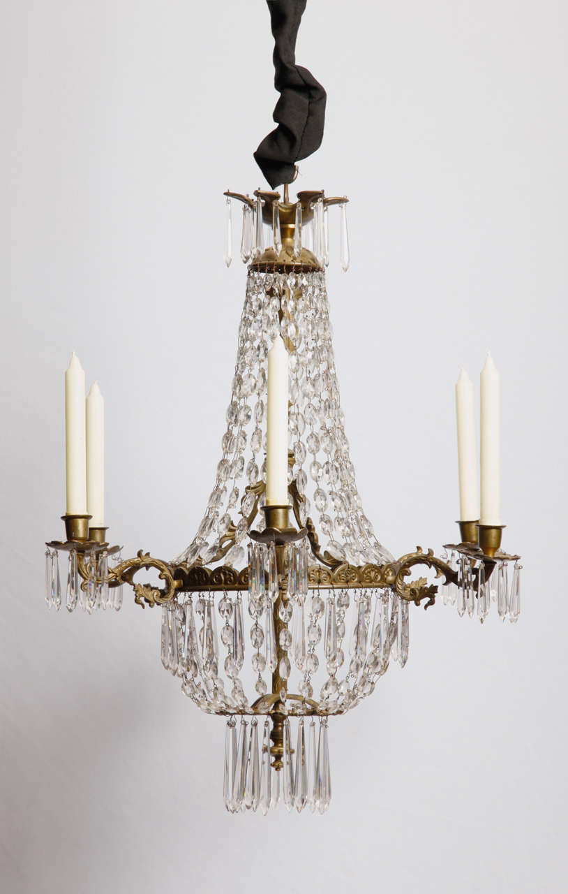 A French Regency period bronze and cut glass 6 light ' Sac a Perles ' chandelier around 1830. About 1800, some unknown French lighting device manufacturer developed the 