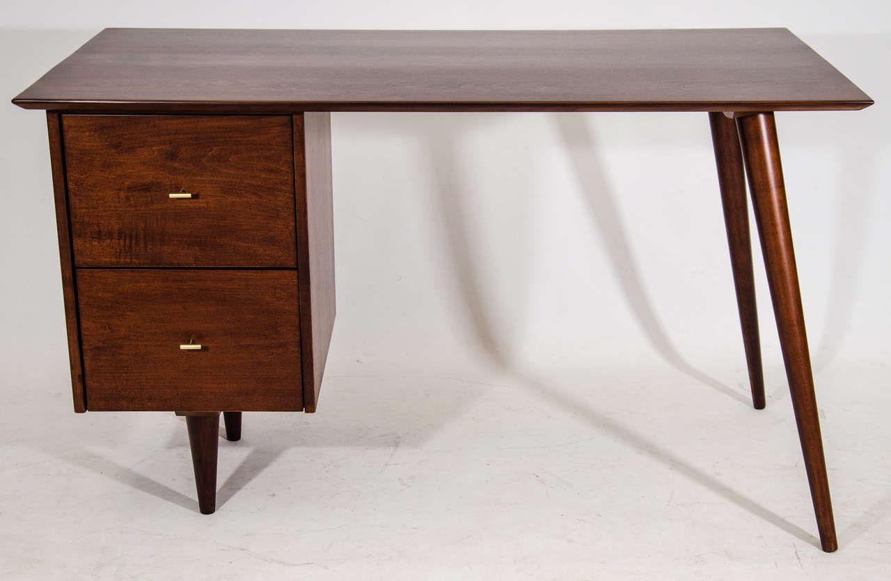 Handsome Planner Group desk designed by Paul McCobb. Stained in a rich brown and accented with rare McCobb designed pulls. Please contact for location.