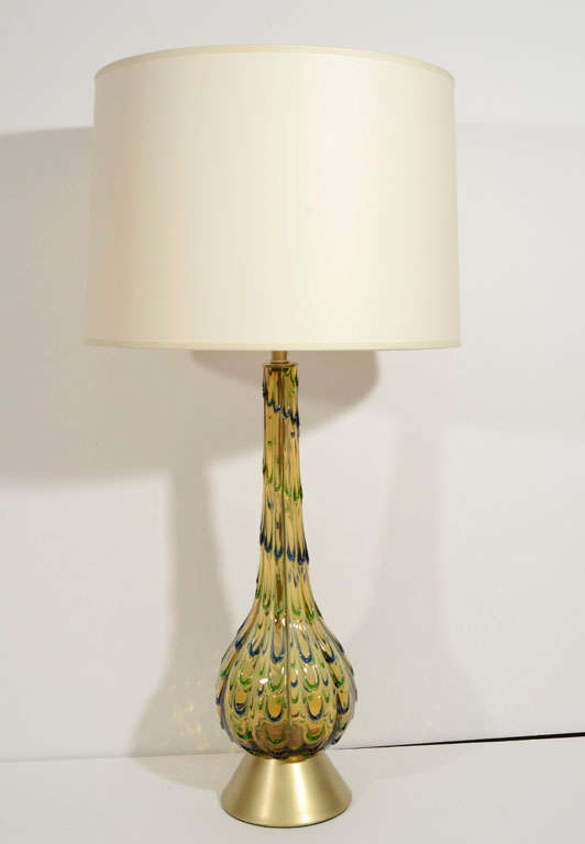 A pair of midcentury Italian Murano glass table lamps of an elongated gourd shape of amber fluted glass with green and blue
teardrop design on new satin brass rewired bases. The pair of ivory paper shades is not included, but can be purchased for