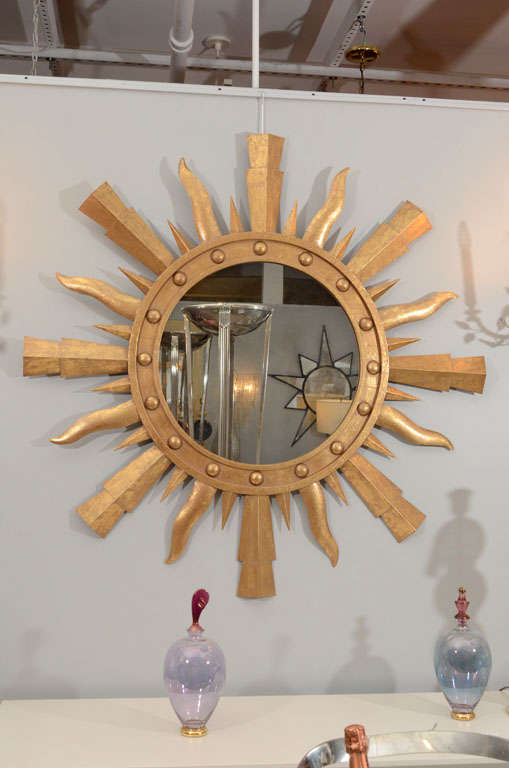 Add a bit of whimsy and drama to a space with this unique and striking gilt metal sunburst mirror. The piece is composed of a center molded ring with raised circular beads and is surrounded by variegated rays.