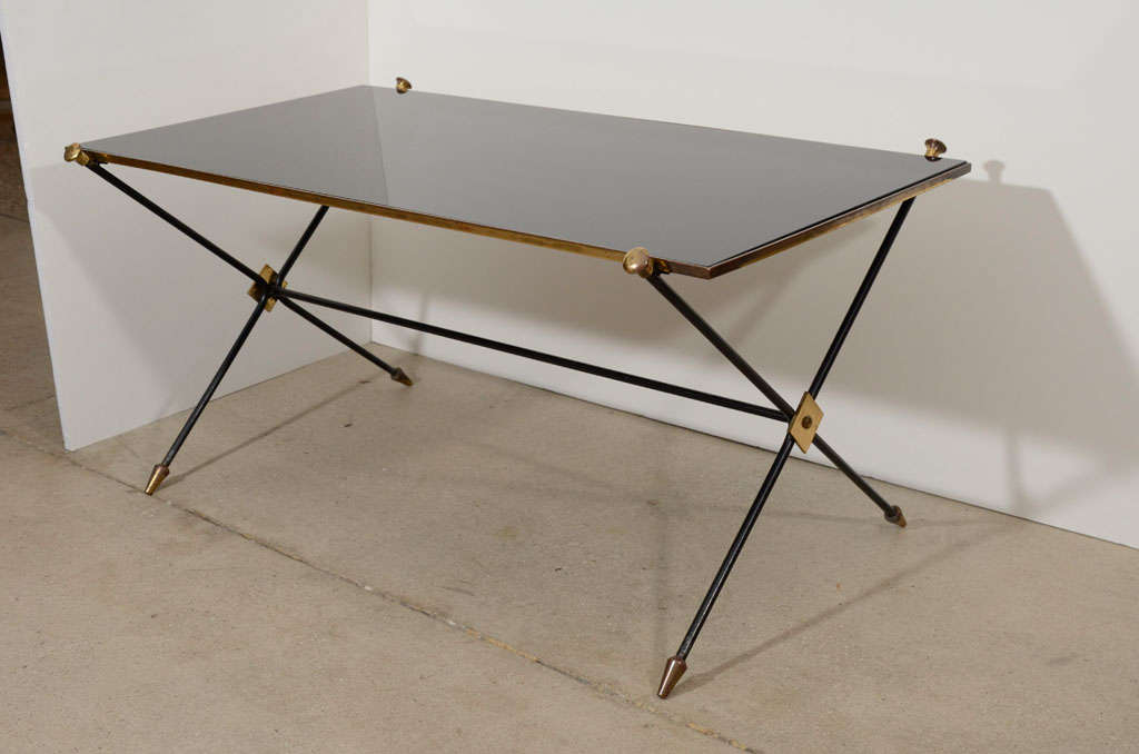 A handsome table with iron and brass X-form base with opaline glass top, attributed to Maison Jansen.