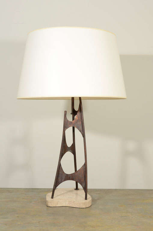 The shaped travertine base supporting an abstract enameled steel column.   (The shade is not included in the price.)