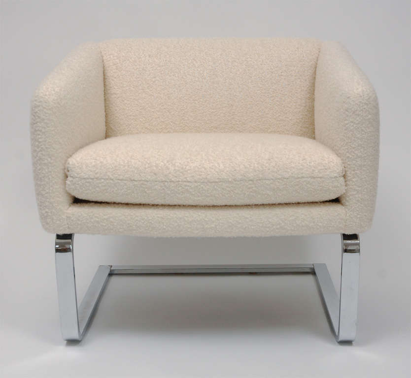 Great pair of club chairs by Selig. Seats newly upholstered in a creamy white wool boucle rest on Cantilevered chrome bases. Sleek and modern design.