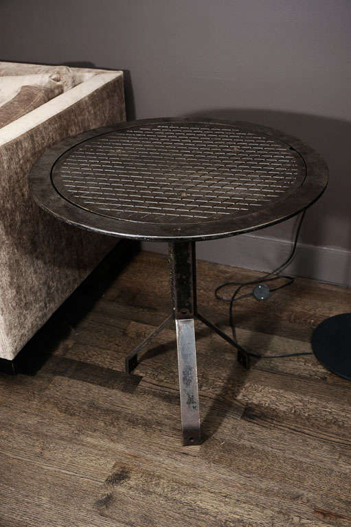 An industrial manhole cover comes back to life to serve as an industrial accent side table. With a tripod base, it adds character and texture to any space.
