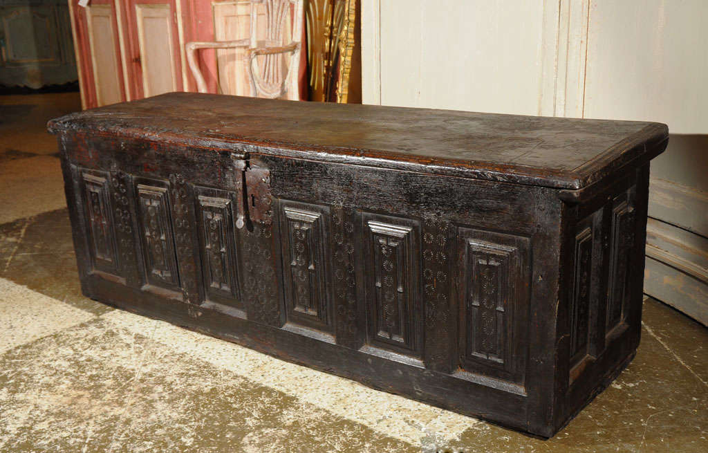 Catalan chestnut trunk with a six fielded panel front exhibiting delicate pinwheel stamping, original iron latch and escutcheon, interior candle till, and  two paneled sides.  This chest has been fully restored and has an excellent rich patina.