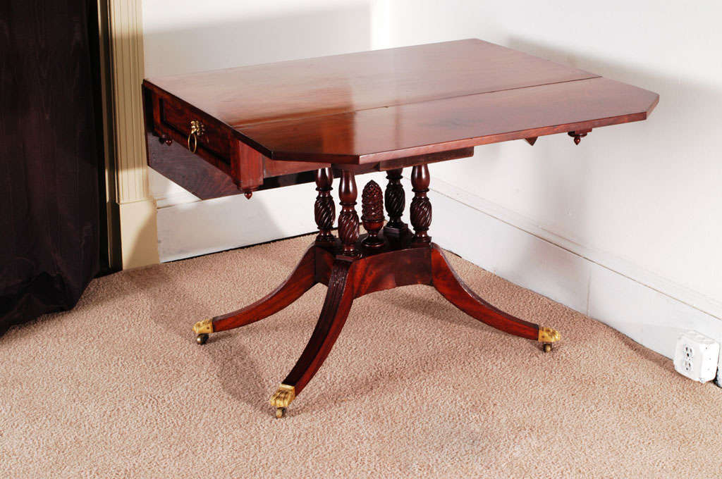 We believe this oversized Pembroke table was made in the workshop of Duncan Phyfe. It can serve a multitude of purposes, including small dining table, center table, sofa table or library table. It has incredible hand carving and graceful