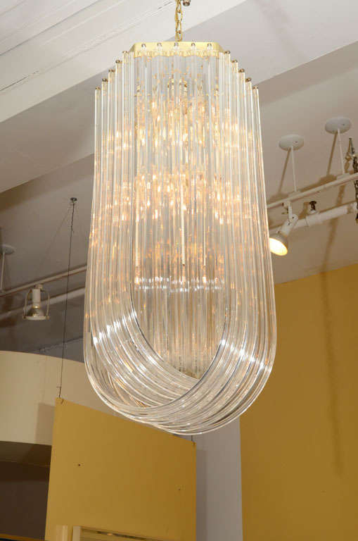 Three long loops of sculpted lucite hang from a gold tone crown and a white interior armature. Located in Las Venus at ABC Home, 646-602-3519