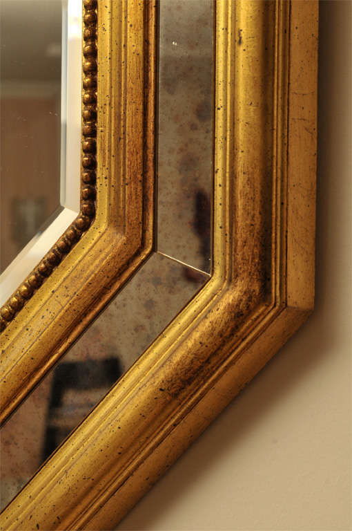 French hexagonal wall mirror composed with a central beveled mirror and "églomisé" tiles. Twin frame in gilded wood .