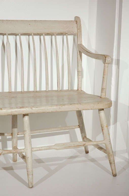 THIS FANTASTIC ORIGINAL WHITE PAINTED NEW ENGLAND SETTLE HAS REGULAR SPINDLES AND EVERY SIX SPINDLE IS ARROW BACK FORM.THE BENCH HAS MORTISSED ARMS AND WOOD PEG & SQUARE NAIL CONSTRUCTION.THE SURFACE OF THE OYSTER WHITE PAINT IS WONDERFUL.THE PIECE