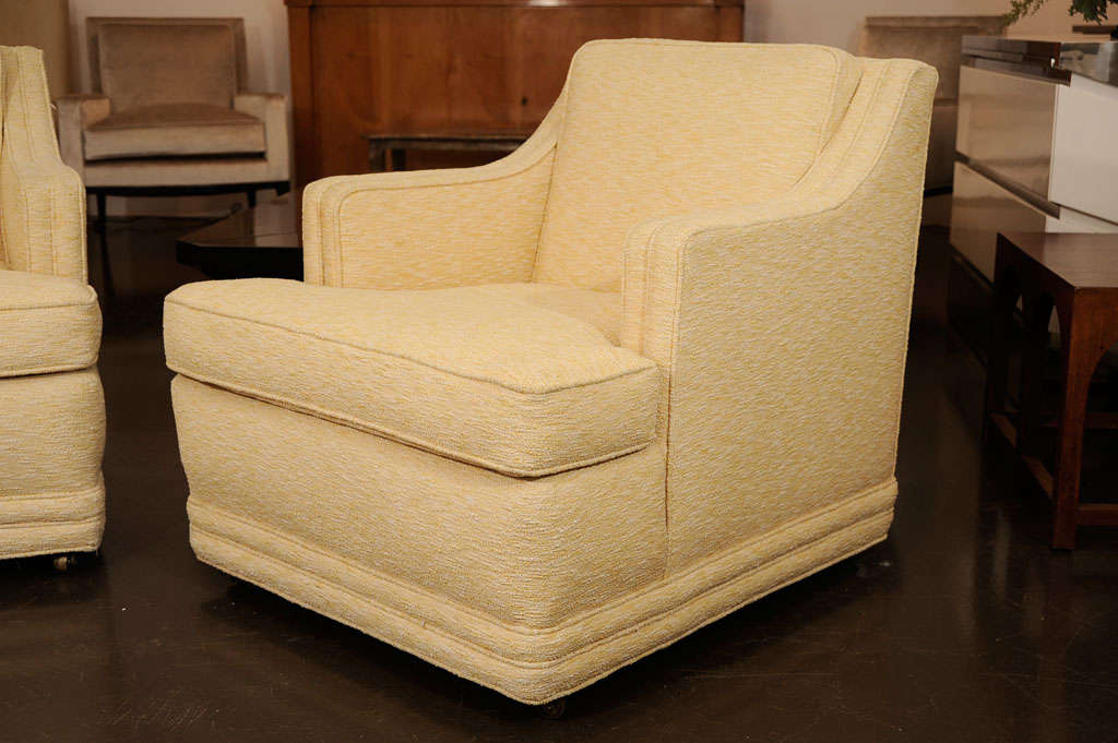 Edward Wormley<br />
Pair of lounge chairs upholstered in pale yellow nubby tweed <br />
with beautiful welted details.<br />
Loose seat cushion and attached back cushion. On casters.<br />
Executed by Dunbar.<br />
American, c. 1950