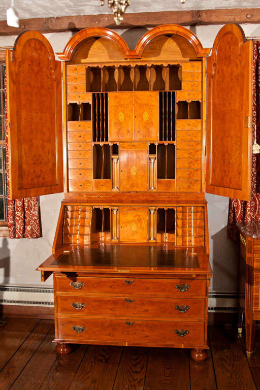 Double dome, Queen Anne style secretary or slant front bureau bookcase on bun feet in English Yewwood with Yew burl accents. Upper case is outfitted with myriad pigeon holes and drawers as well as cupboards with inlaid doors. Slant front desk has
