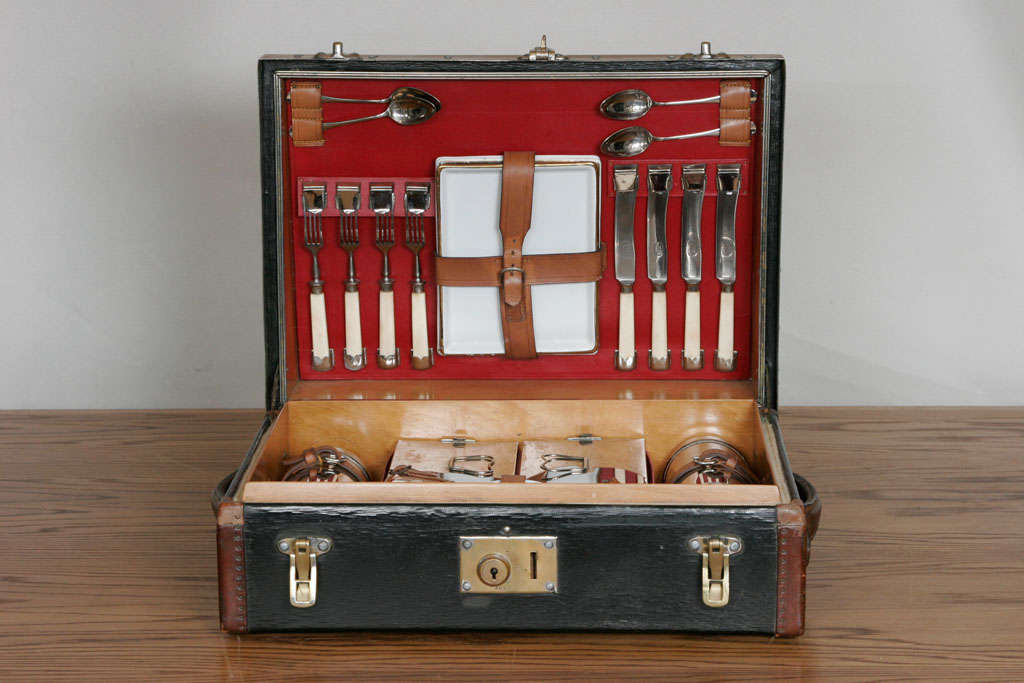 Full picnic set for 4 people including silver plated flasks and original sandwich boxes. <br />
Studded top and brass edged case with leather handles and trim makes for an unusual, motoring case to transport it.