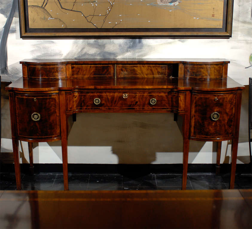 Unusual shaped George II style 1840's Scottish Mahogany Sideboard with satinwood stringing around doors, drawers, and legs. Shaped gallery with sliding center doors. Shaped center drawer. Cellarette on left with cabinet on right. Tapered legs with