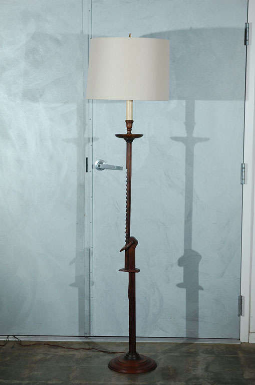 This American floor lamp, circa 1940's, is in wood and may be adjusted in height. You may easily raise or lower the top section of the lamp which is held in place with the ratcheting device located on the column. 