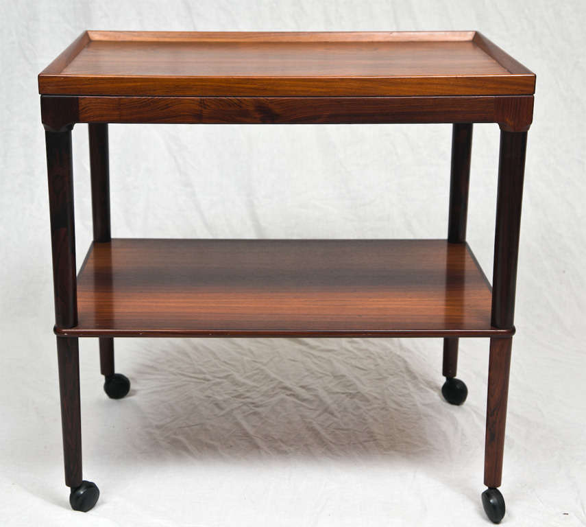 Lovely drinks cart with rimmed edge in rosewood. Wheels make this cart perfect for parties. Rosewood is highly grained and in excellent condition. Denmark 1960's. Please write to info@galliplimodern.com for trade price and shipping costs.